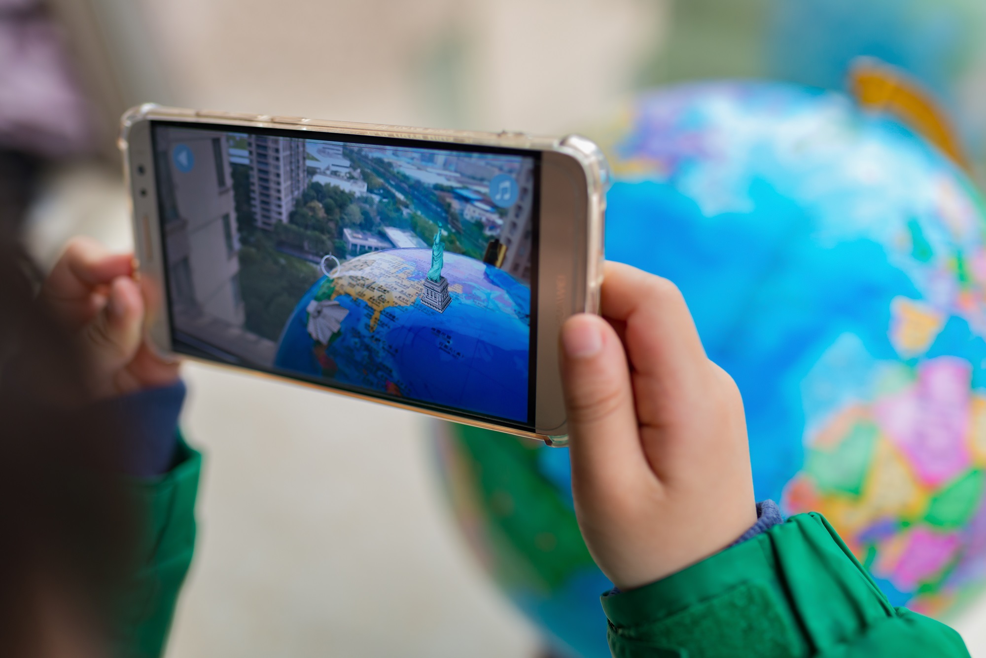 Person taking a picture of a globe with a smartphone