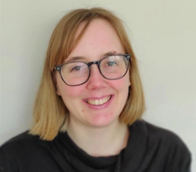 Abigail: Headshot of a smiling woman with glasses on